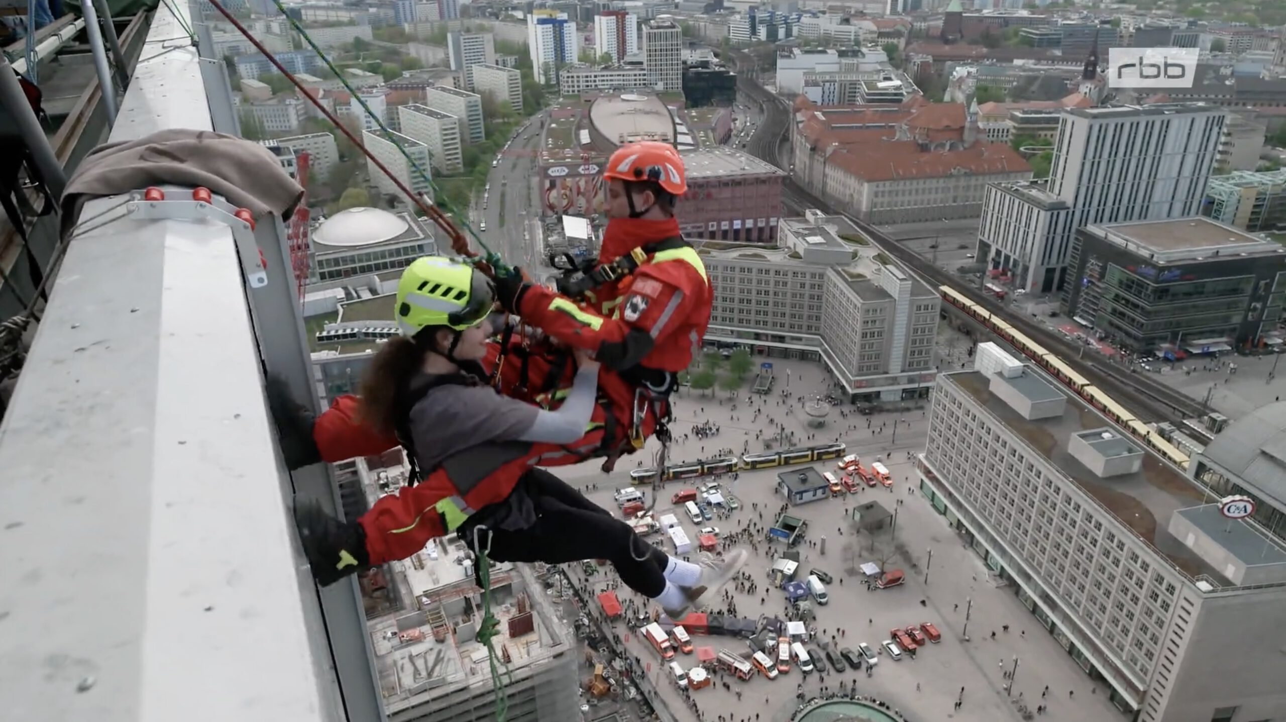 Feuerwehrmann seilt sich mit seiner Freundin vom Hochhaus am Alexanderplatz ab.